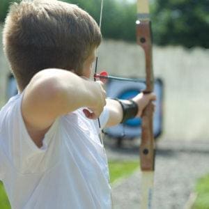 Boy doing archery at a Rock UK centre 